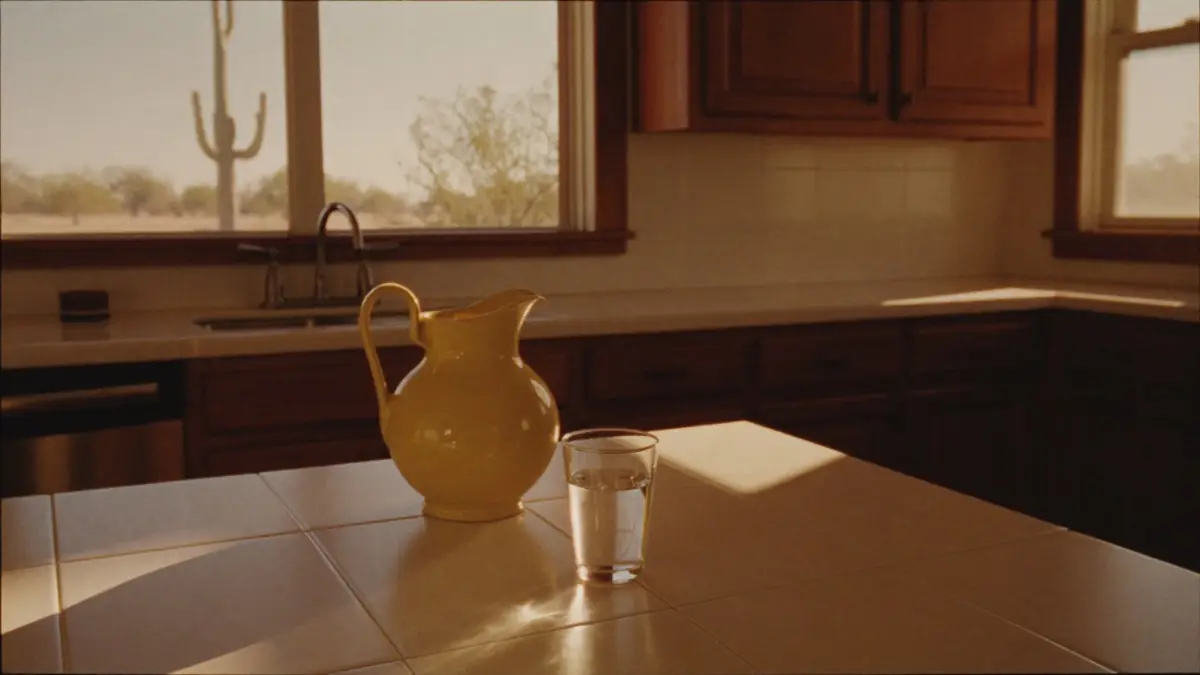 Warm kitchen counter at golden hour, butter pitcher and a glass of water